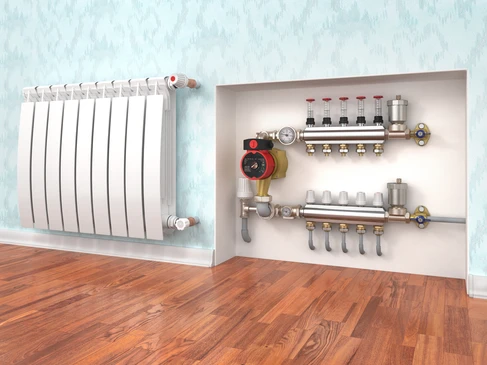 Int&eacute;rieur r&eacute;sidentiel avec radiateur &agrave; ailettes blanches fix&eacute; au mur et syst&egrave;me de chauffage centralis&eacute; visible dans niche murale