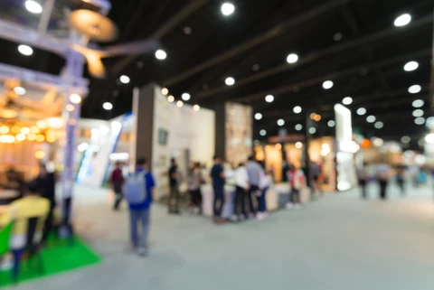 Salon professionnel ou exposition commerciale avec stands d'entreprises, visiteurs circulant entre les espaces d'exposition, ambiance d'événement B2B