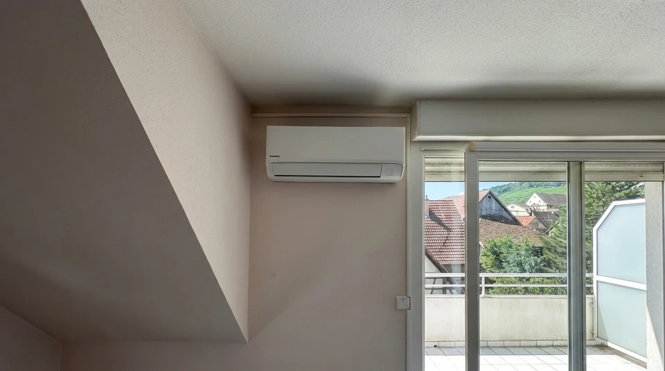 Technicien en combinaison de travail effectuant la maintenance d'une unité de climatisation extérieure