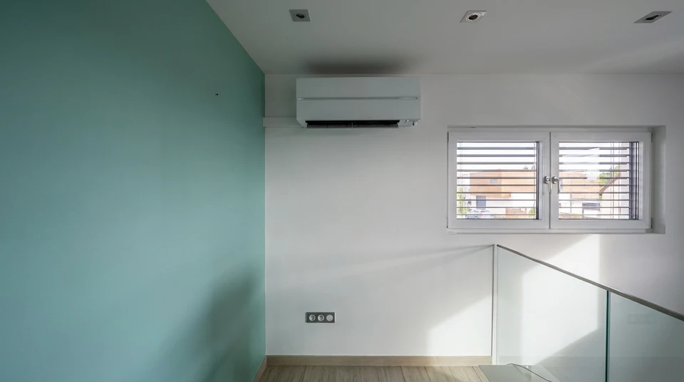 Main avec télécommande dirigée vers l'air conditionné