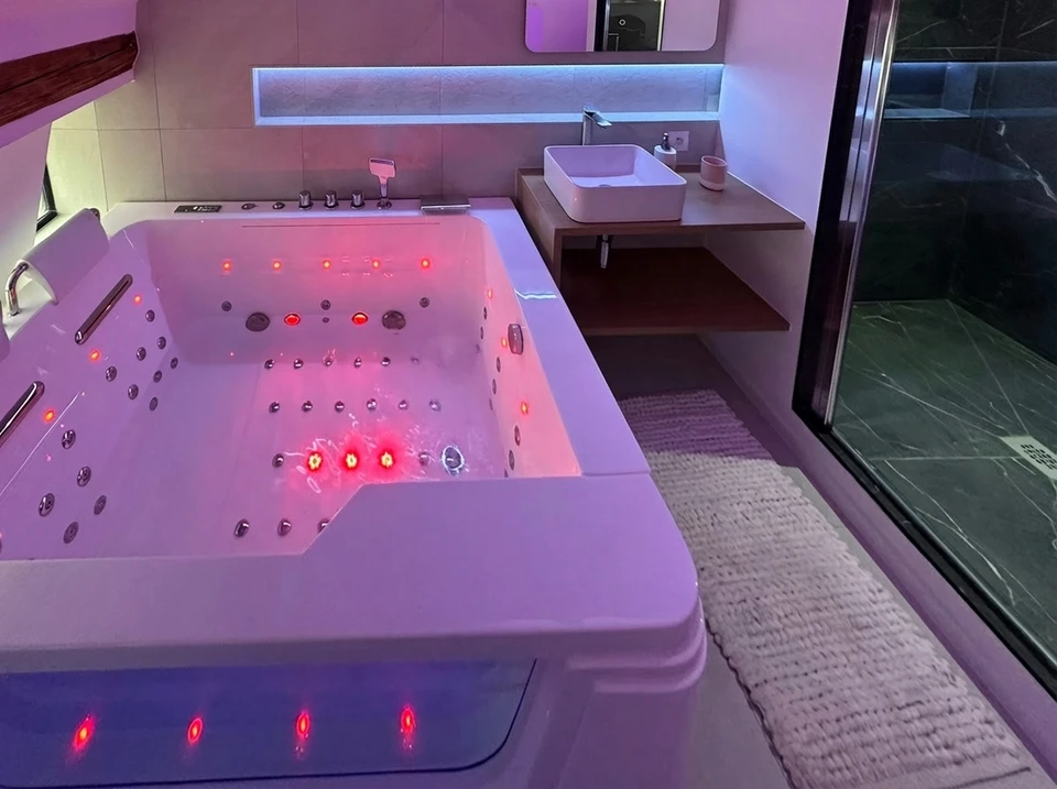 Plombier professionnel en salopette bleue et casque blanc installant un WC suspendu dans une salle de bain en construction